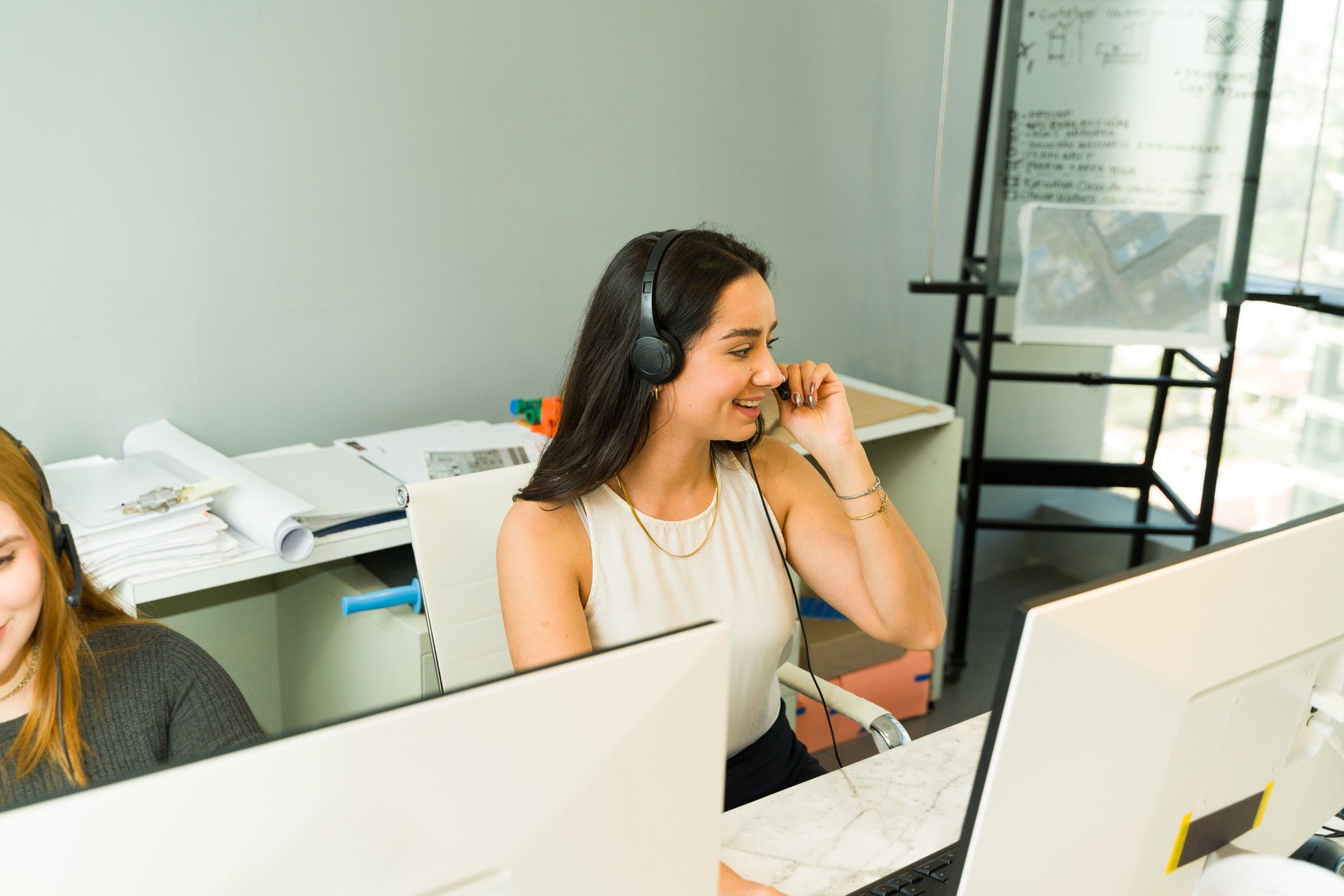 Beautiful Hispanic woman taking calls and trying to make some sales while working in an office